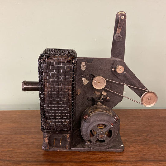 Vintage metal machine on a wooden surface with a plain background