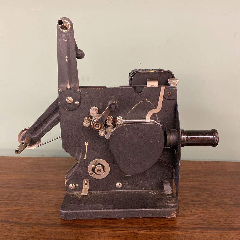 Vintage metal machine on a wooden surface with a light green background