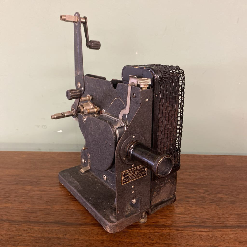Vintage metal machine on a wooden surface with a plain background