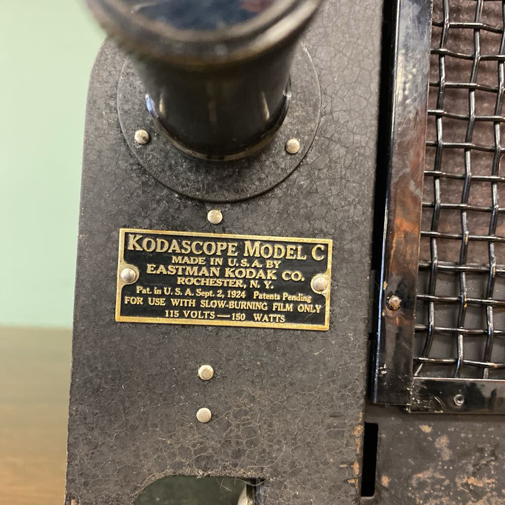 Vintage Kodascope Model C projector with a gold label on a green background