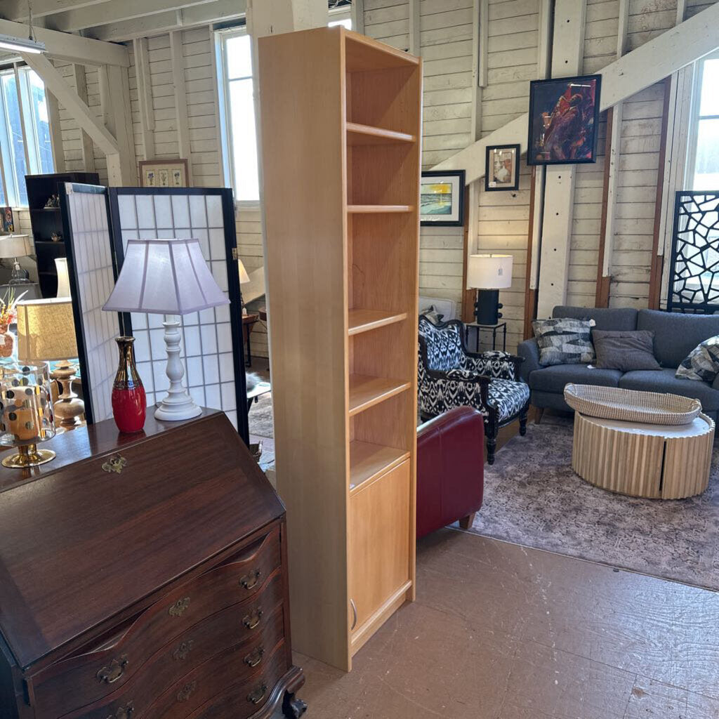 Tall wooden bookshelf in a room with furniture and decor