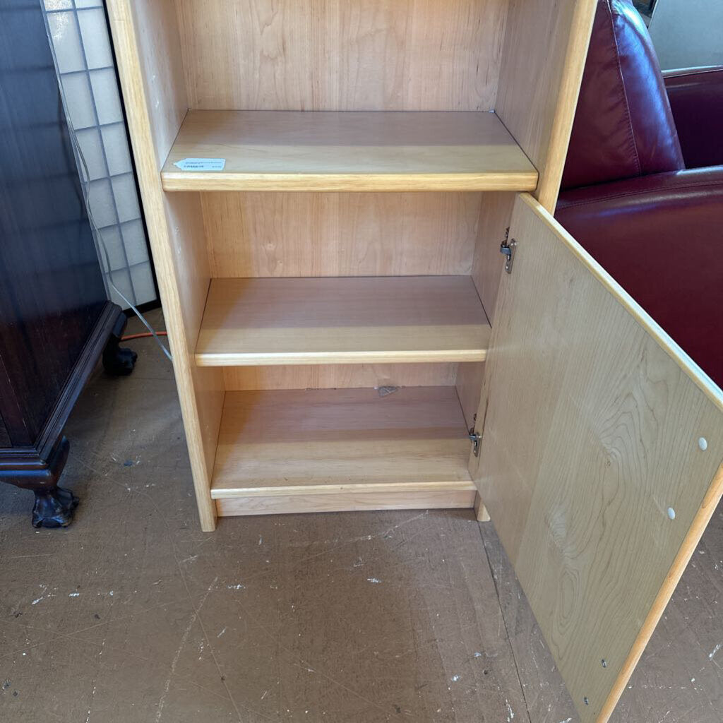 Wooden bookshelf with open door in a room setting