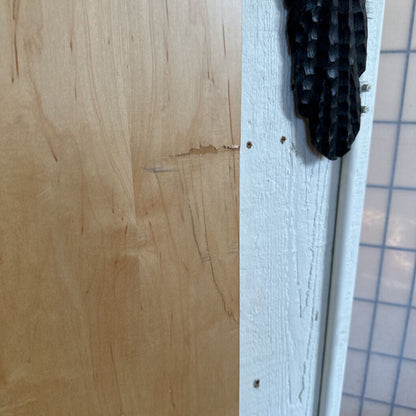 Close-up of a wooden surface with a white strip and black textured object.