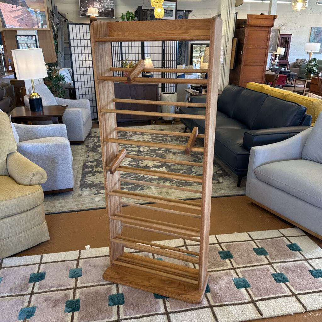 Wooden CD rack in a living room setting with furniture and decor.