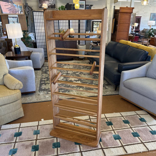 Wooden CD rack in a living room setting with furniture and decor.
