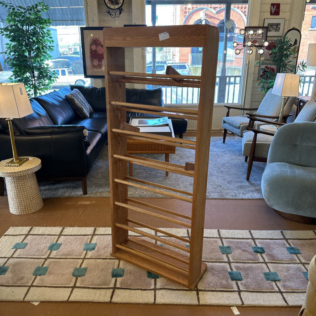 Wooden bookshelf in a living room setting with furniture and decor.
