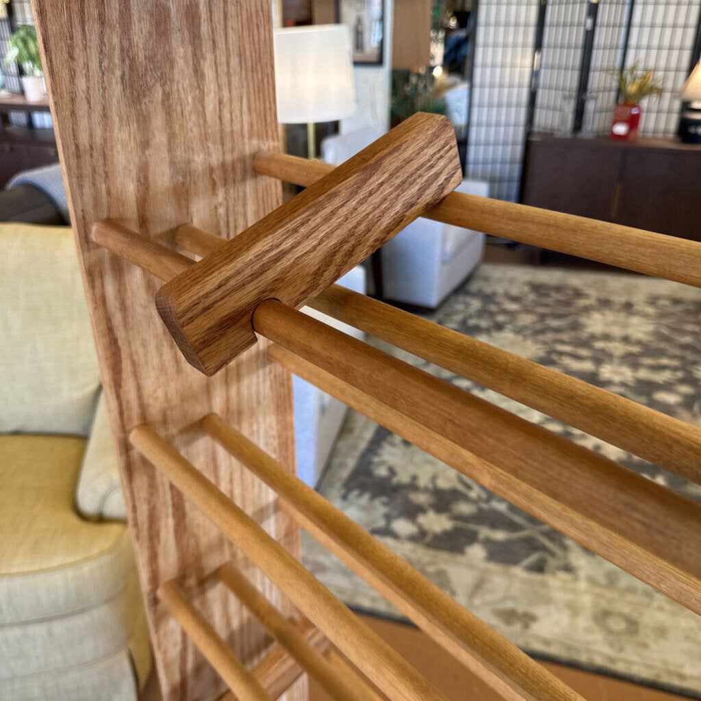 Wooden coat rack in a living room setting with furniture and decor in the background