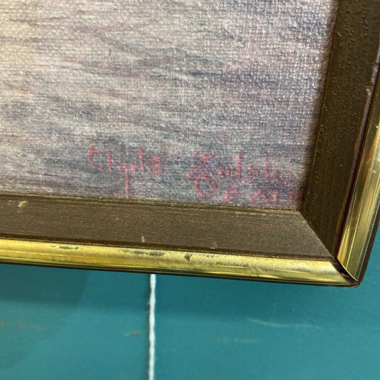 Signature on a textured surface with a gold frame