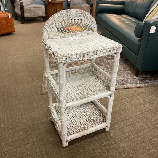 White wicker side table in a room with furniture