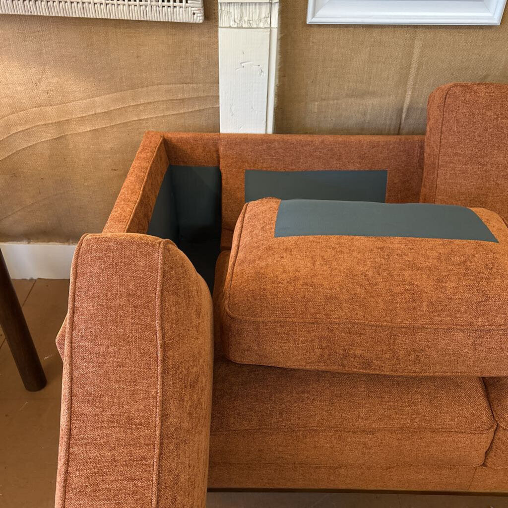 Brown upholstered chair with gray cushions in a room setting.