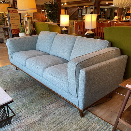 Gray sofa in a room with green walls and decorative lamps.