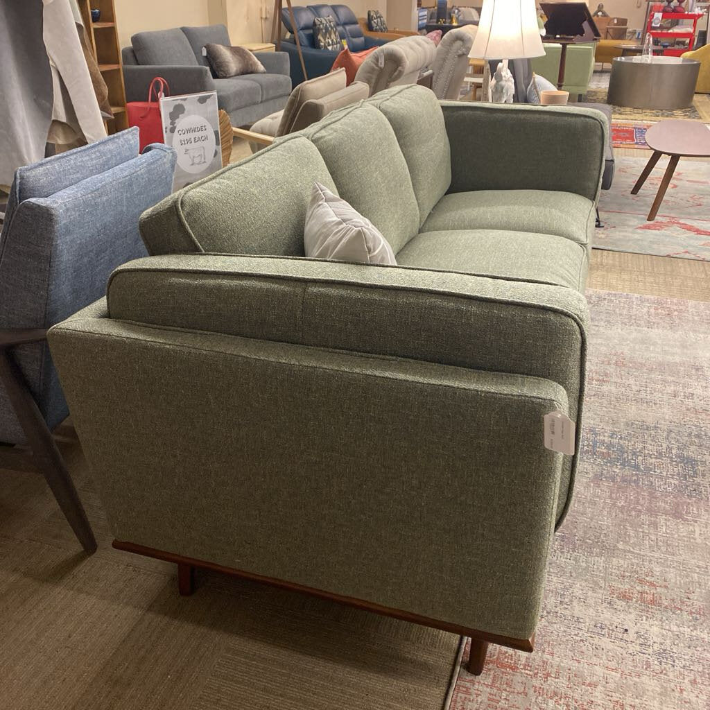 Green sofa in a showroom with other furniture in the background