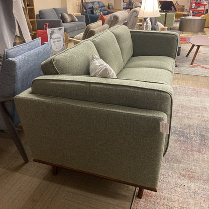 Green sofa in a showroom with other furniture in the background