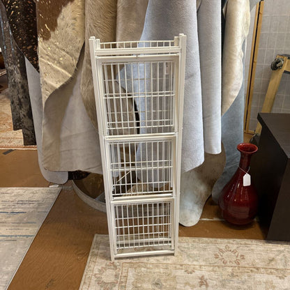 White metal ladder against a textured wall with draped fabric