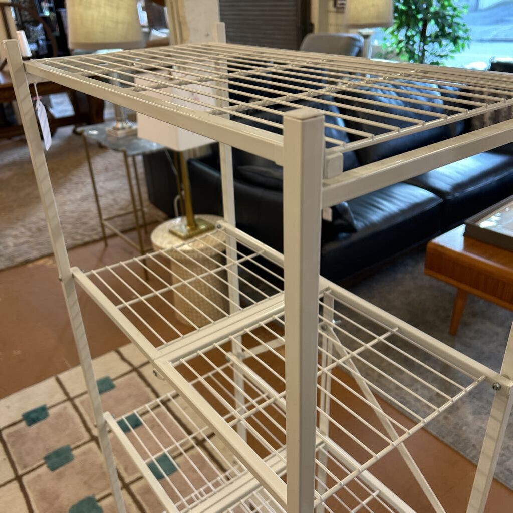 Metal shelving unit in a living room setting with furniture and decor.