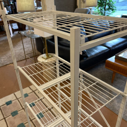 Metal shelving unit in a living room setting with furniture and decor.