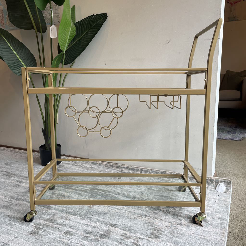 Gold metal serving cart with wheels in a room setting