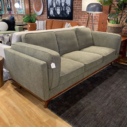 Gray sofa with a price tag in a store setting