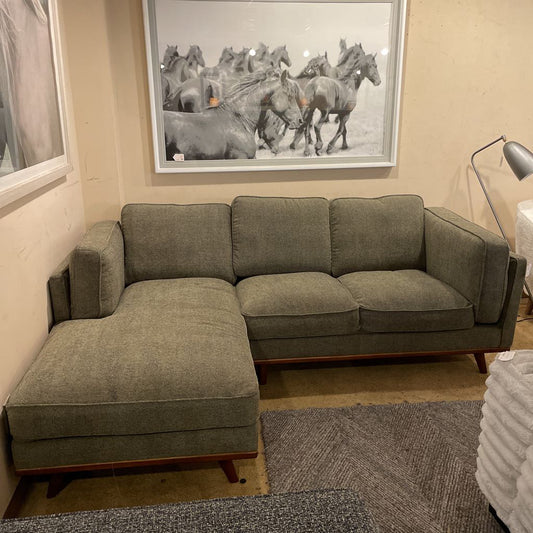 Gray sectional sofa in a room with a horse painting on the wall.