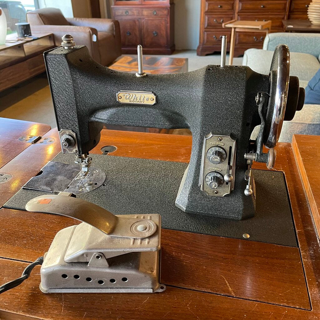 Vintage sewing machine on a wooden table with a home interior background