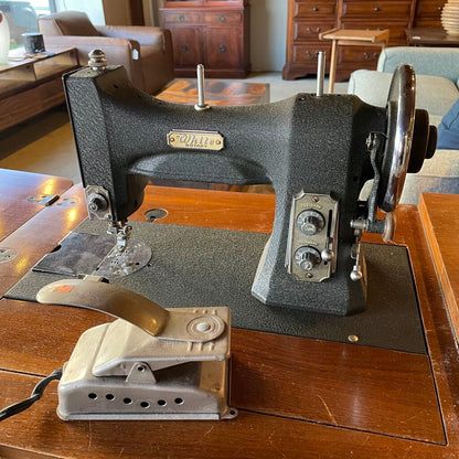 Vintage sewing machine on a wooden table with a home interior background