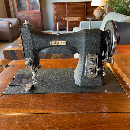 Vintage sewing machine on a wooden table with a home interior background