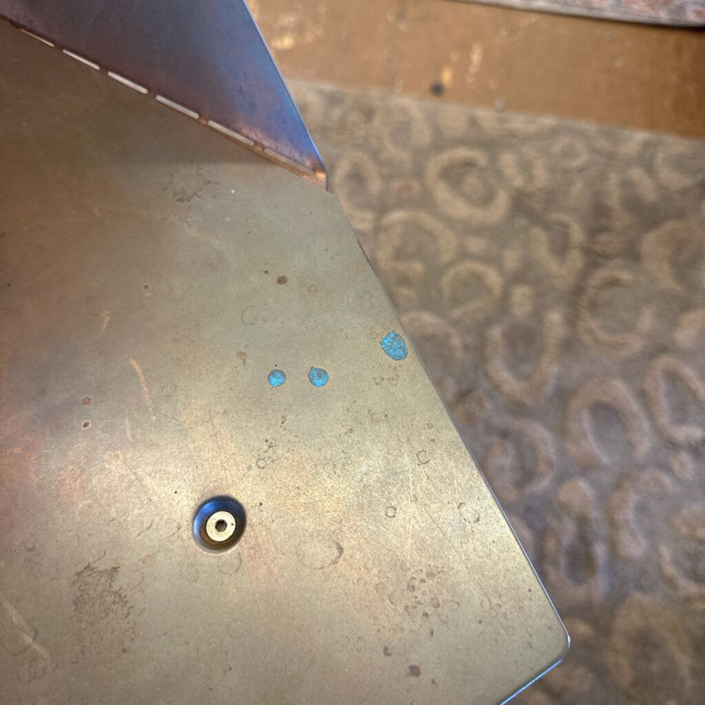 Metal surface with blue and black dots on a textured background