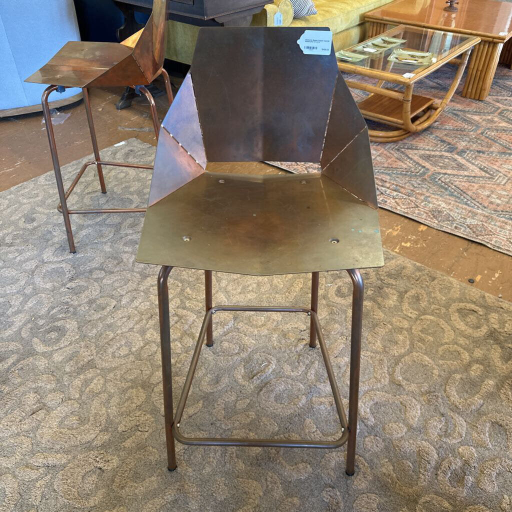 Metal bar stool with a geometric design on a patterned carpet