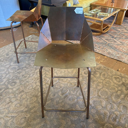 Metal bar stool with a geometric design on a patterned carpet