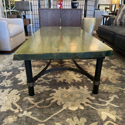 Wooden dining table in a living room setting with chairs and decor.