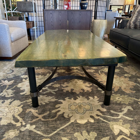 Wooden dining table in a living room setting with chairs and decor.