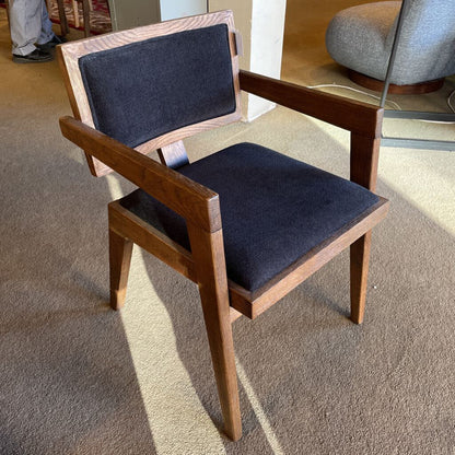 Wooden chair with dark blue cushions on a carpeted floor