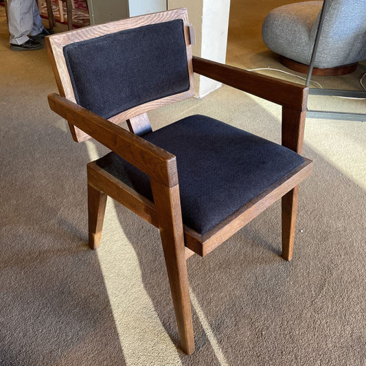Wooden chair with dark blue cushions on a carpeted floor