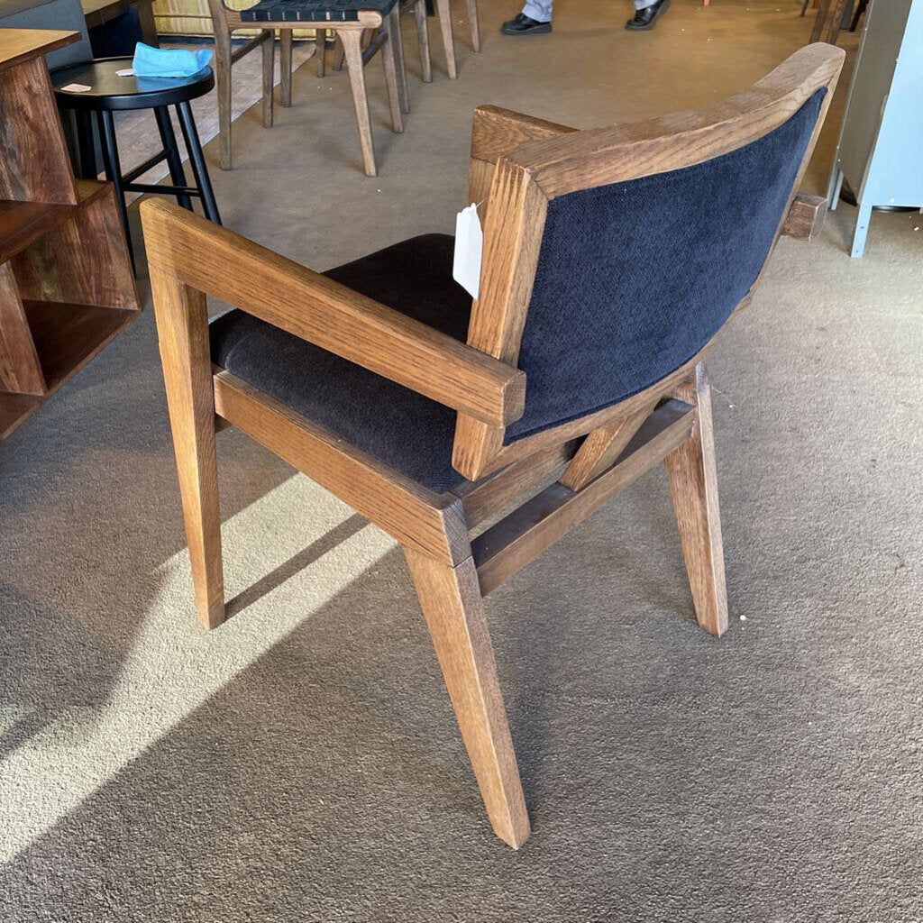 Wooden chair with a blue cushion on a carpeted floor