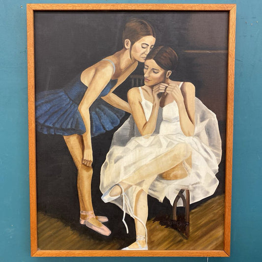 Painting of two women in a wooden frame against a blue wall.