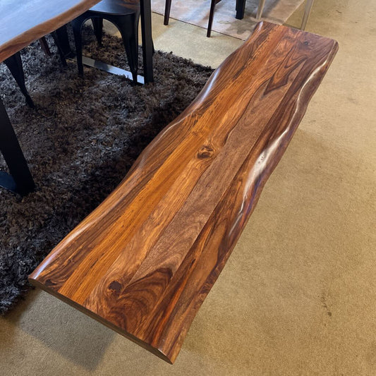 Wooden bench with a natural finish on a carpeted floor