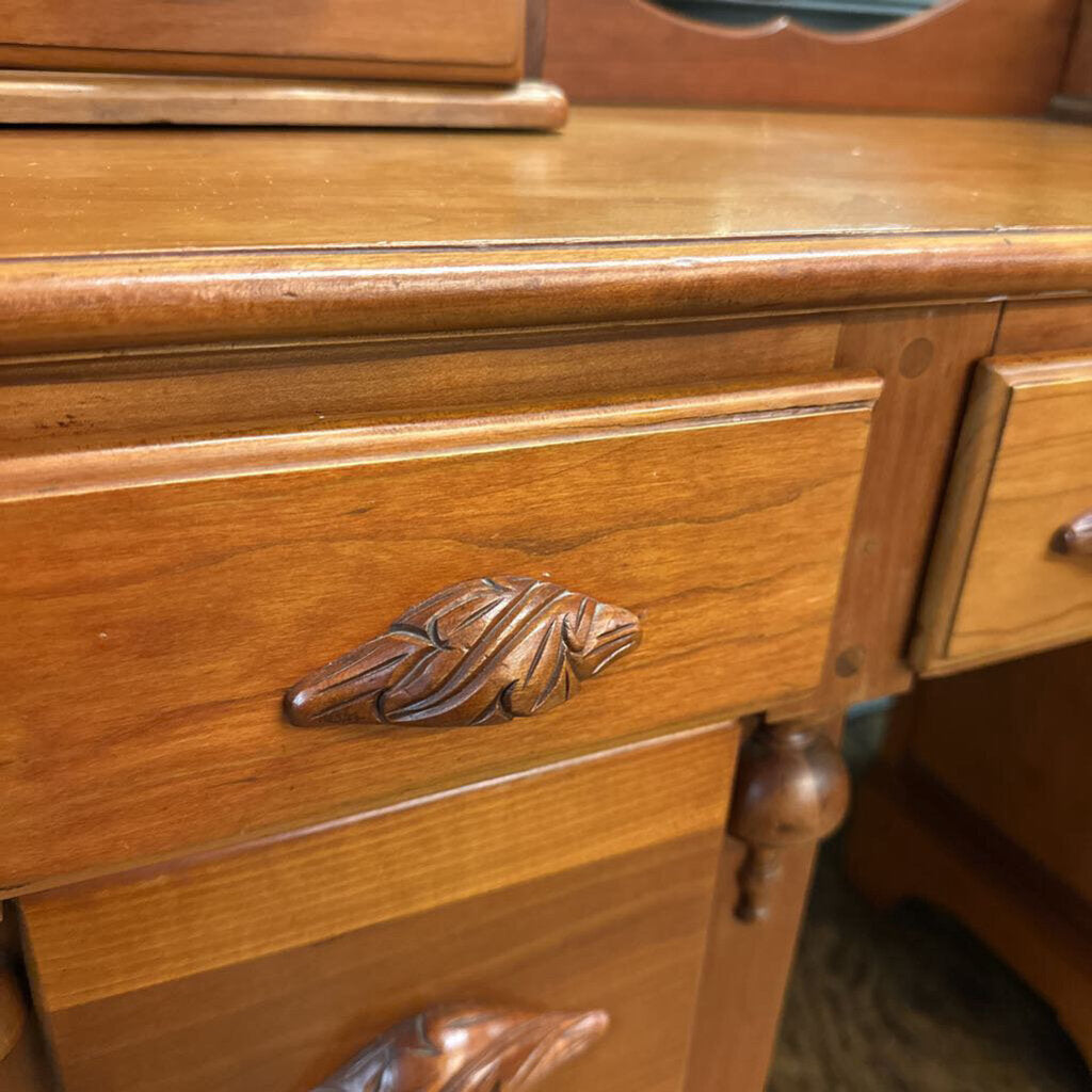 Close-up of a wooden dresser with decorative handles