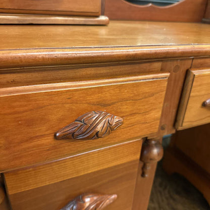 Close-up of a wooden dresser with decorative handles