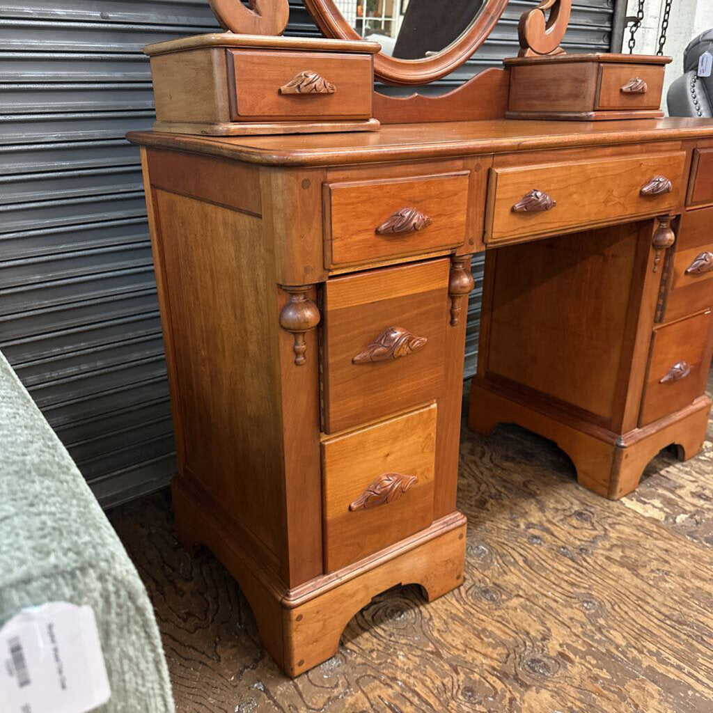 Wooden vanity with drawers and a mirror on top, against a metal shutter background.