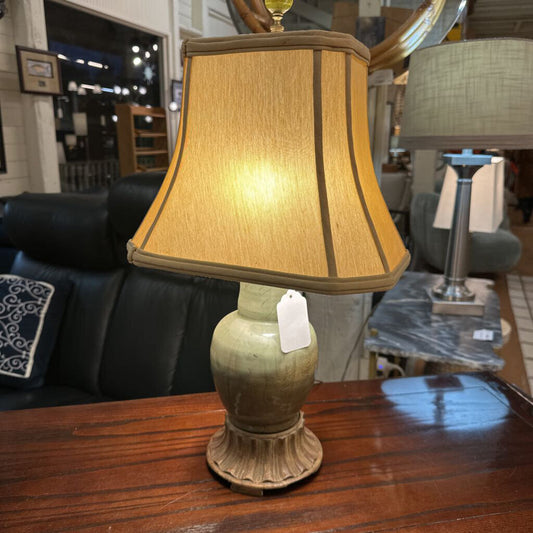 Lamp with a beige shade on a wooden table in a store setting