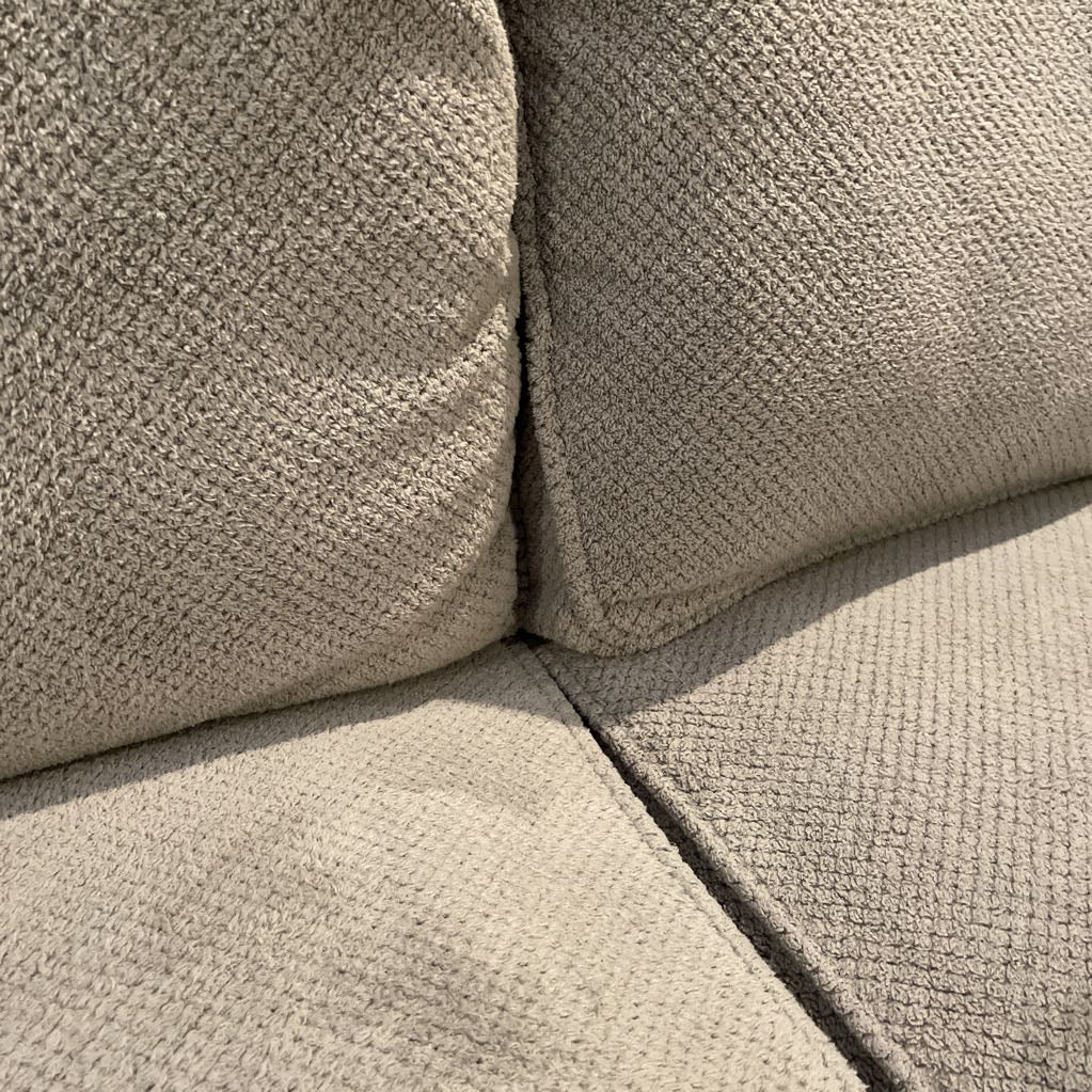 Close-up of a textured beige sofa corner