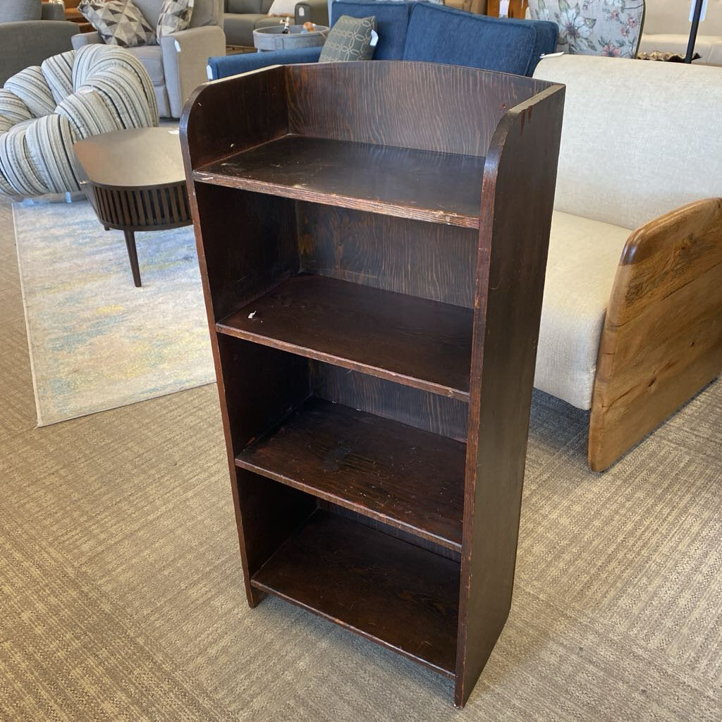 Wooden bookshelf in a living room setting with furniture and decor.