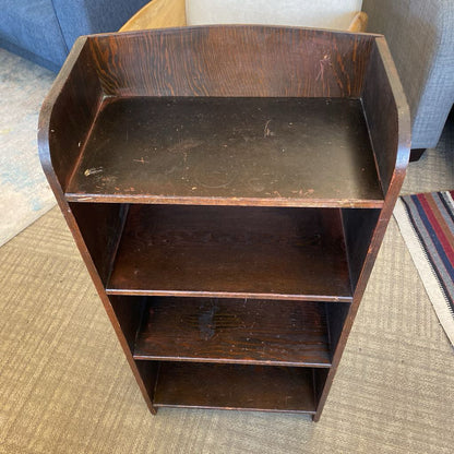 Wooden shelf with three shelves on a carpeted floor