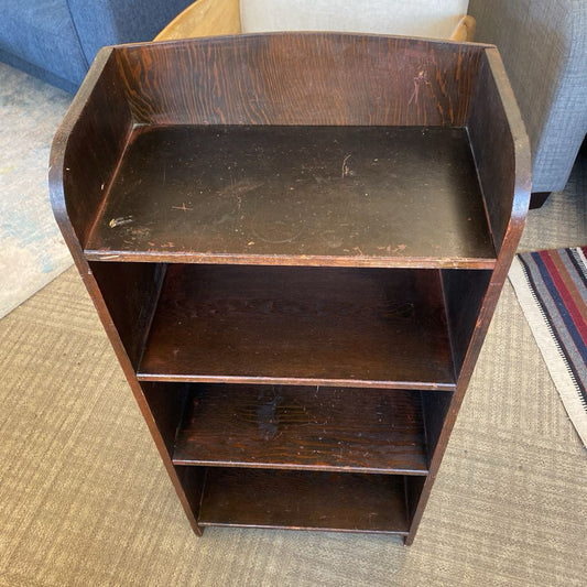 Wooden shelf with three shelves on a carpeted floor