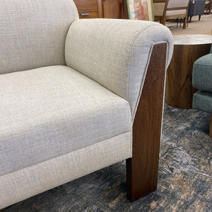 Gray sofa with wooden armrests in a room setting