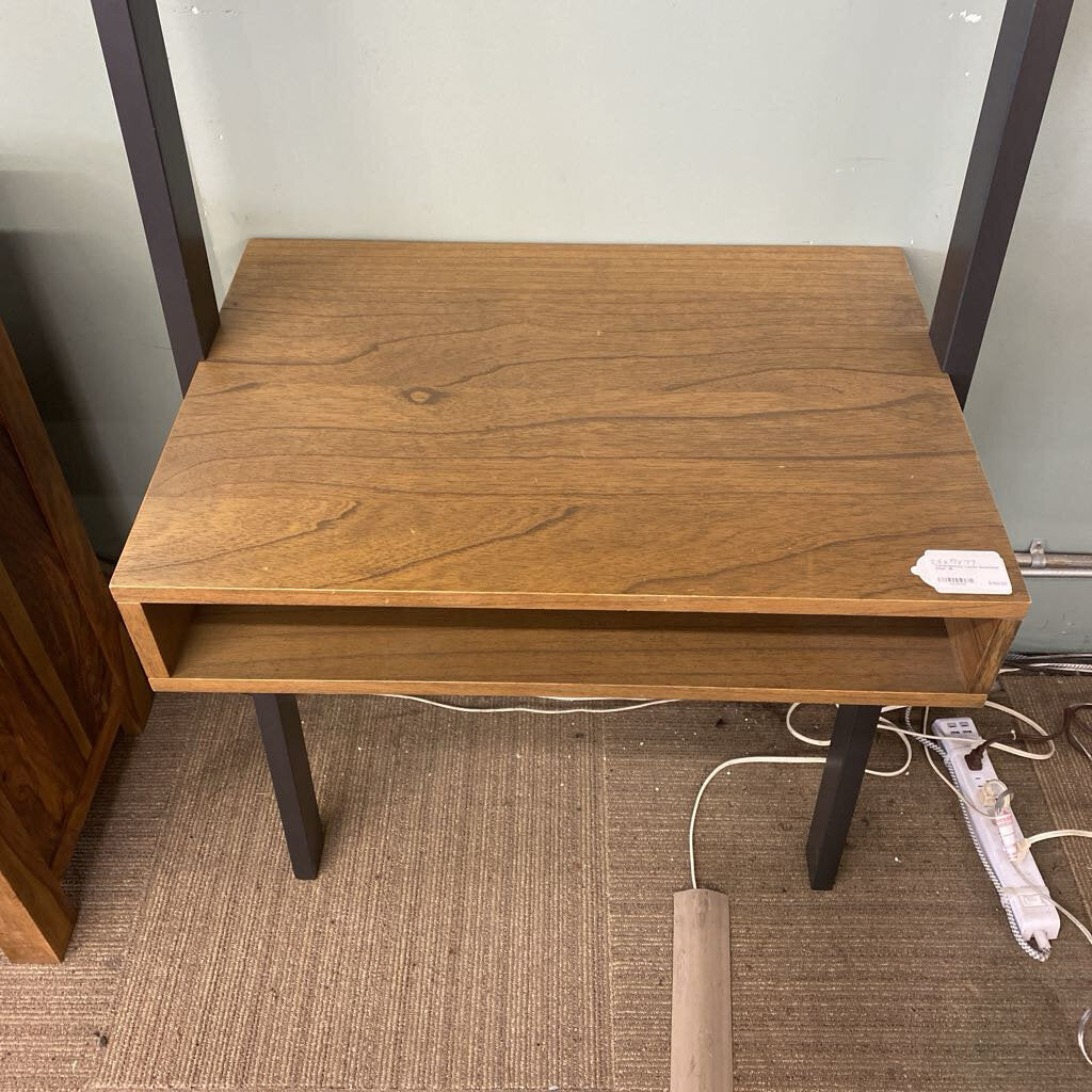 Wooden desk with a shelf on a carpeted floor