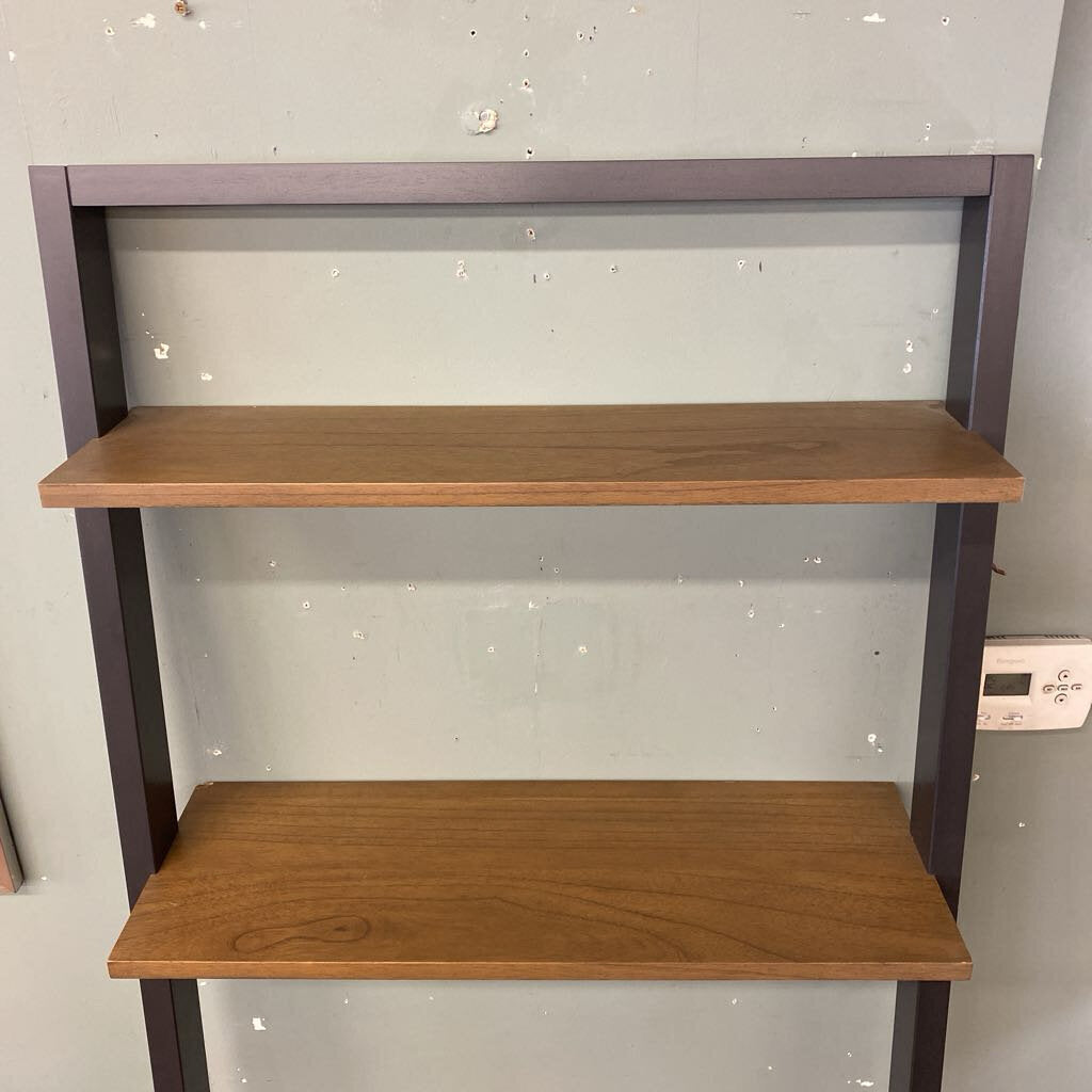 Three-tier wooden shelf with metal frame against a light gray wall.
