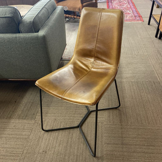 Brown leather chair with black metal legs on a carpeted floor.