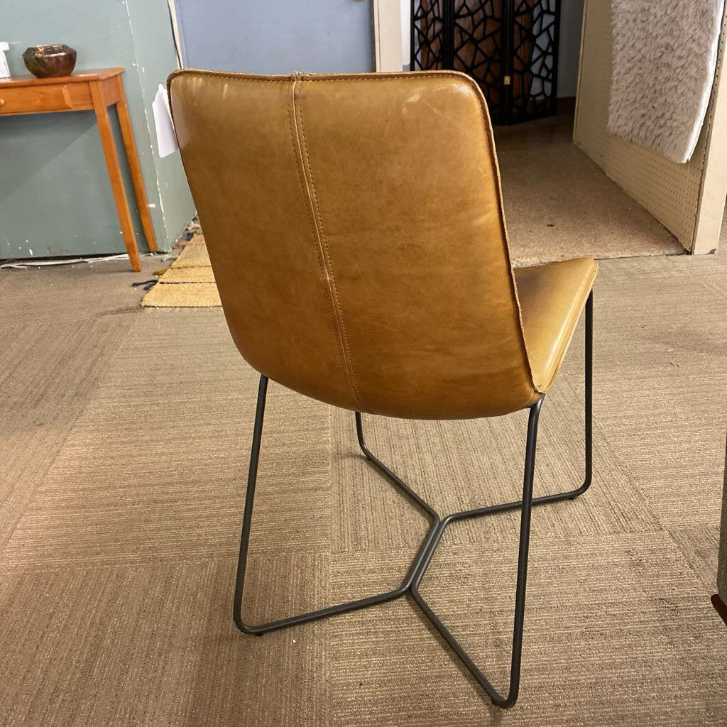 Brown leather chair with black metal legs on a carpeted floor.