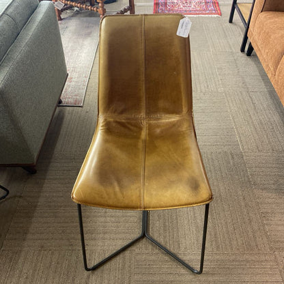 Brown leather chair with a black metal frame on a carpeted floor.